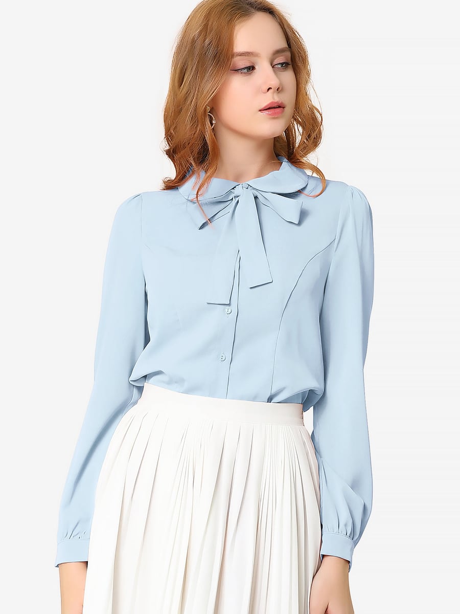De frente, en azul claro con falda plisada