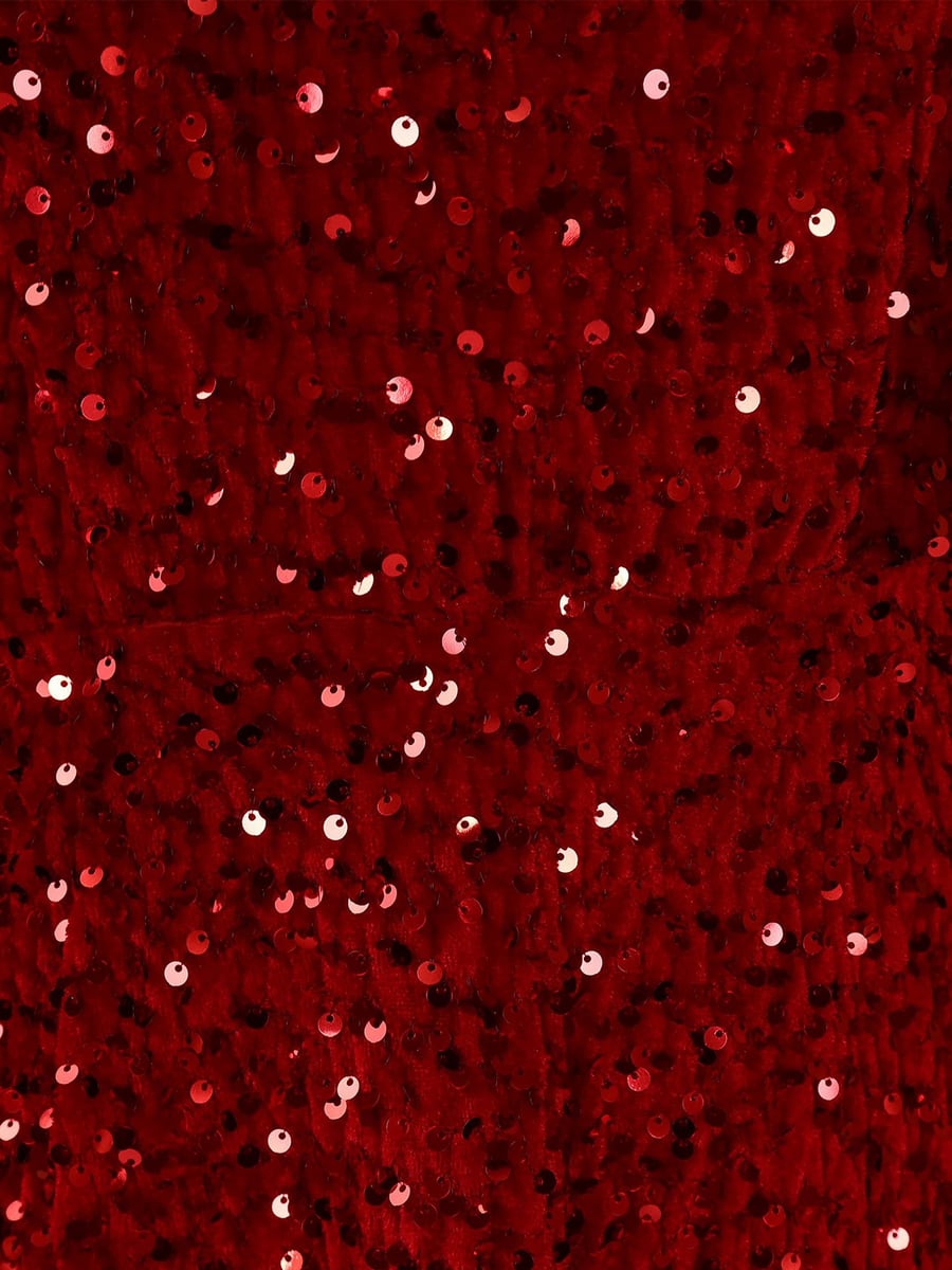 Close-up of sequins on red velvet