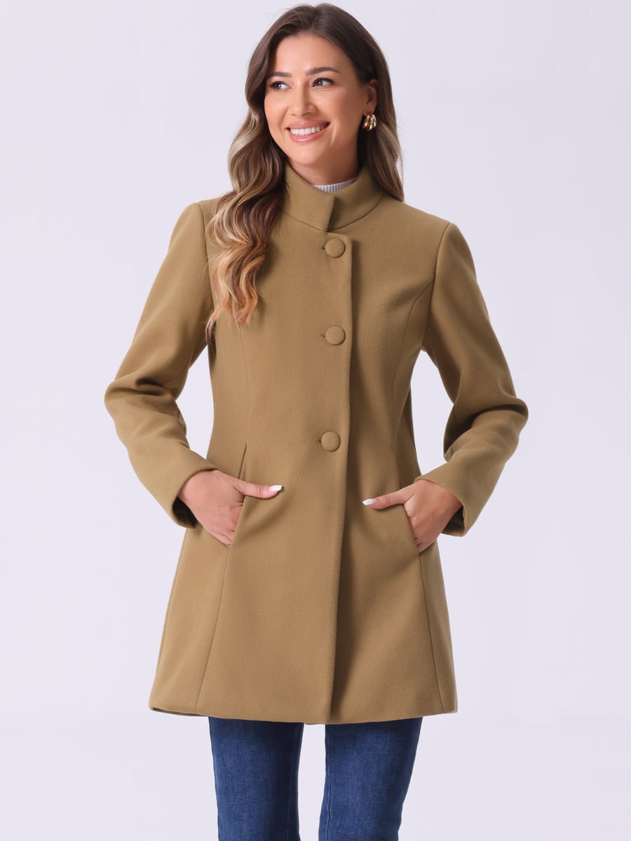 Front view in camel, buttoned with hands in pockets
