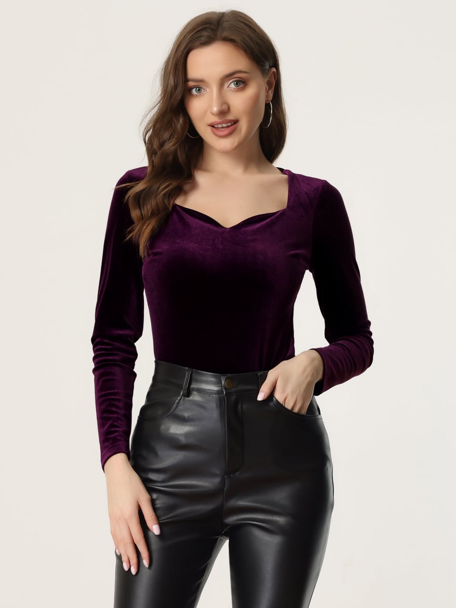 De frente, en morado con pantalón de piel