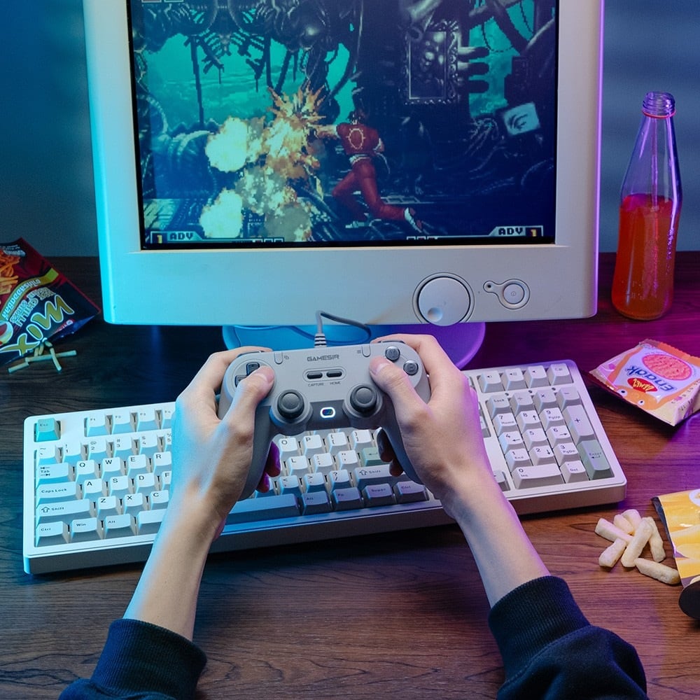 Hands playing in front of a retro monitor
