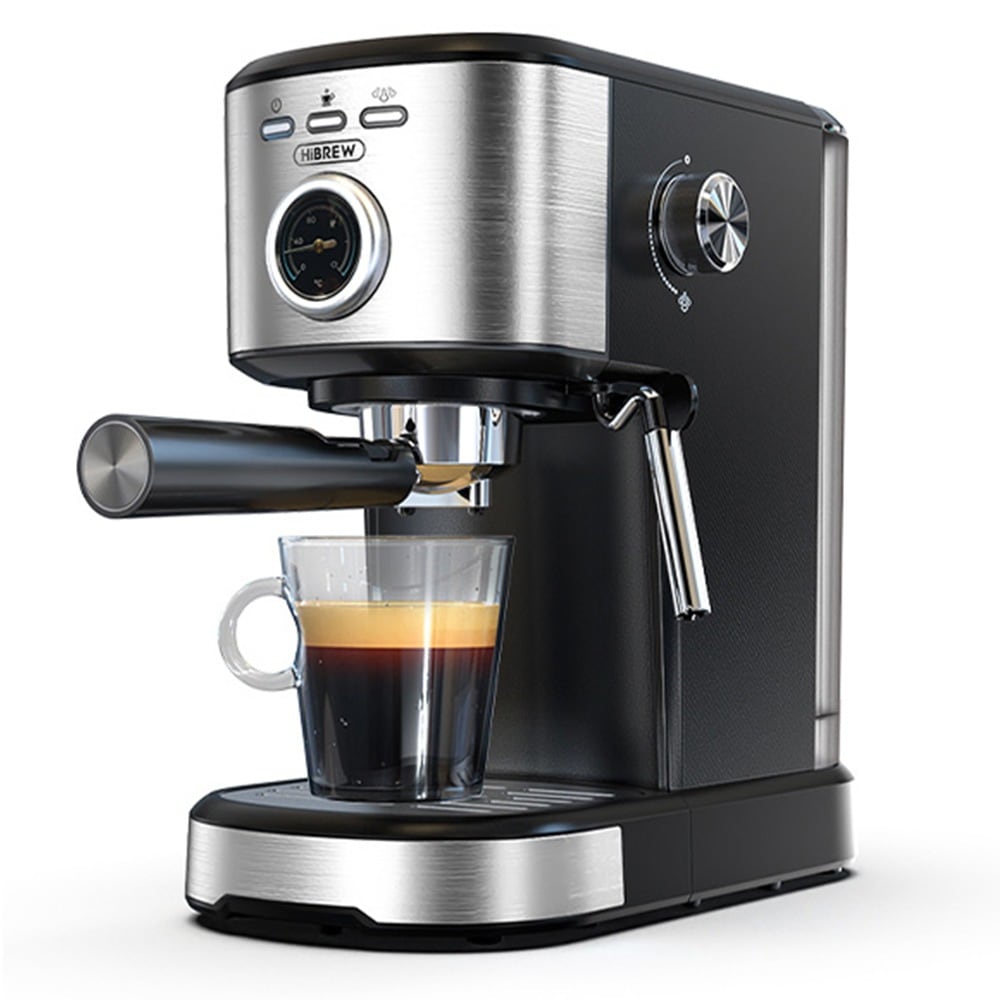 La máquina plateada y negra sirviendo un espresso en un vaso