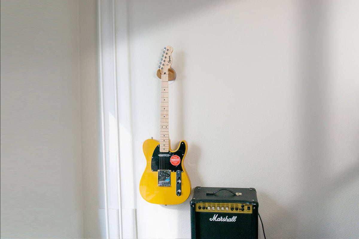 Una Telecaster colgada junto al ampli