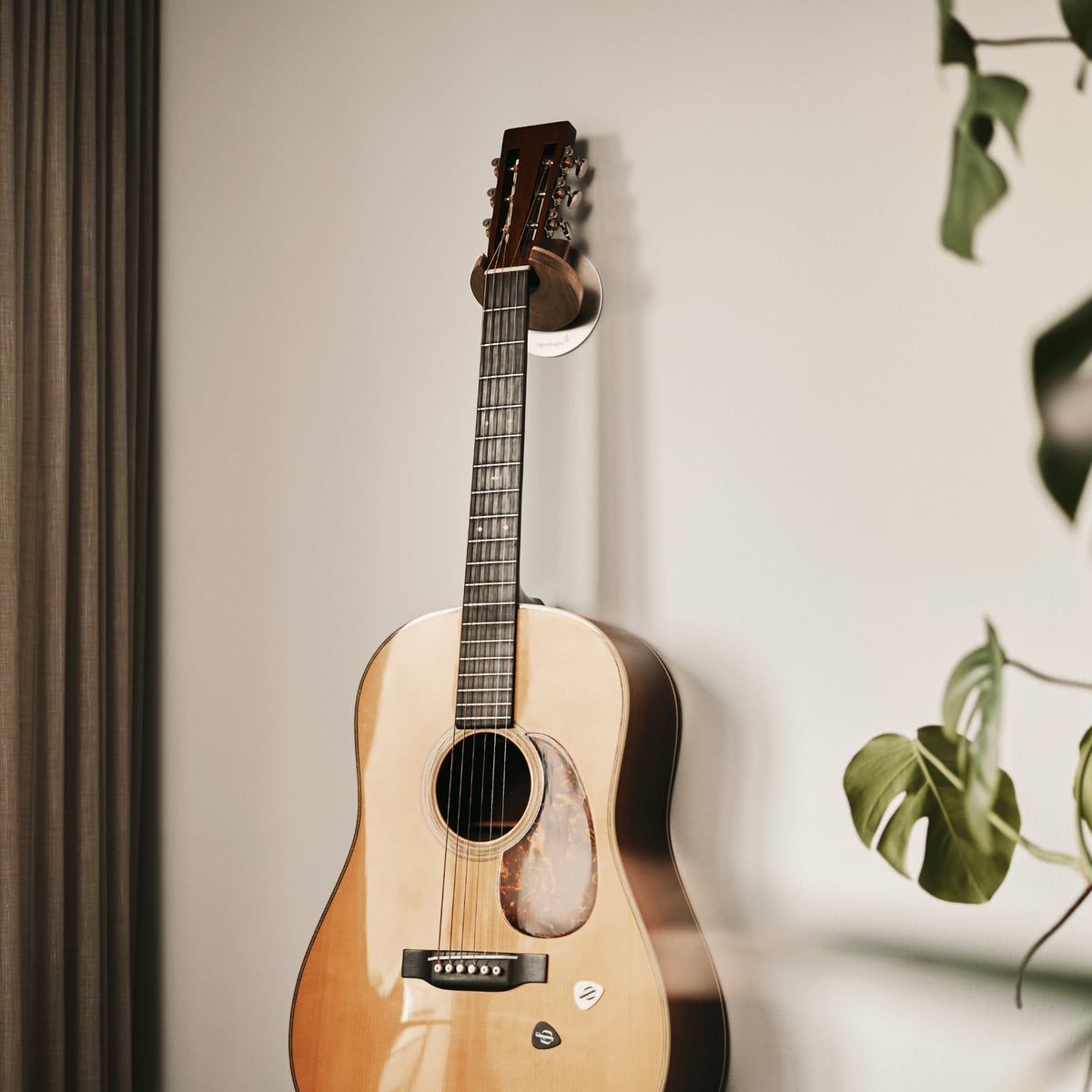 An acoustic guitar hung on the wall