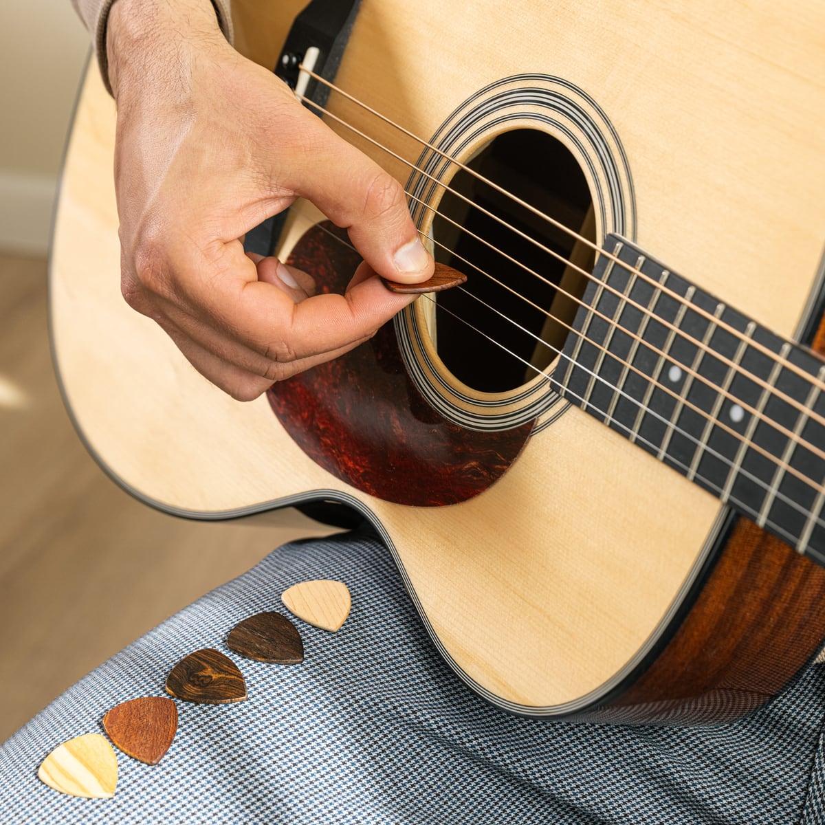 Tocando una acústica con las púas al lado