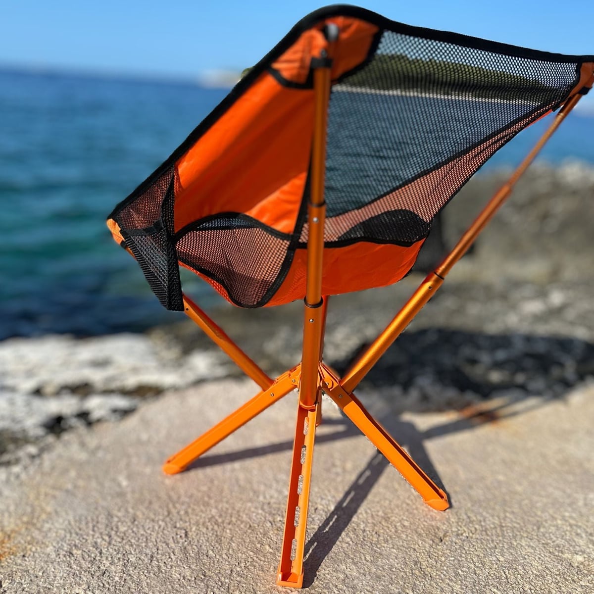 La silla naranja montada en las rocas junto al mar